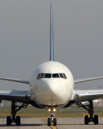 White aircraft taxi on taxiway at the airport